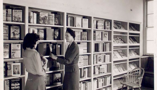 "Librarian with young reader in Browsing Room of the Nathan Strauss Branch for Young People" The New York Public Library Digital Collections.